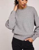 Woman wearing a gray crew neck sweater