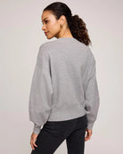Woman wearing a gray crew neck sweater