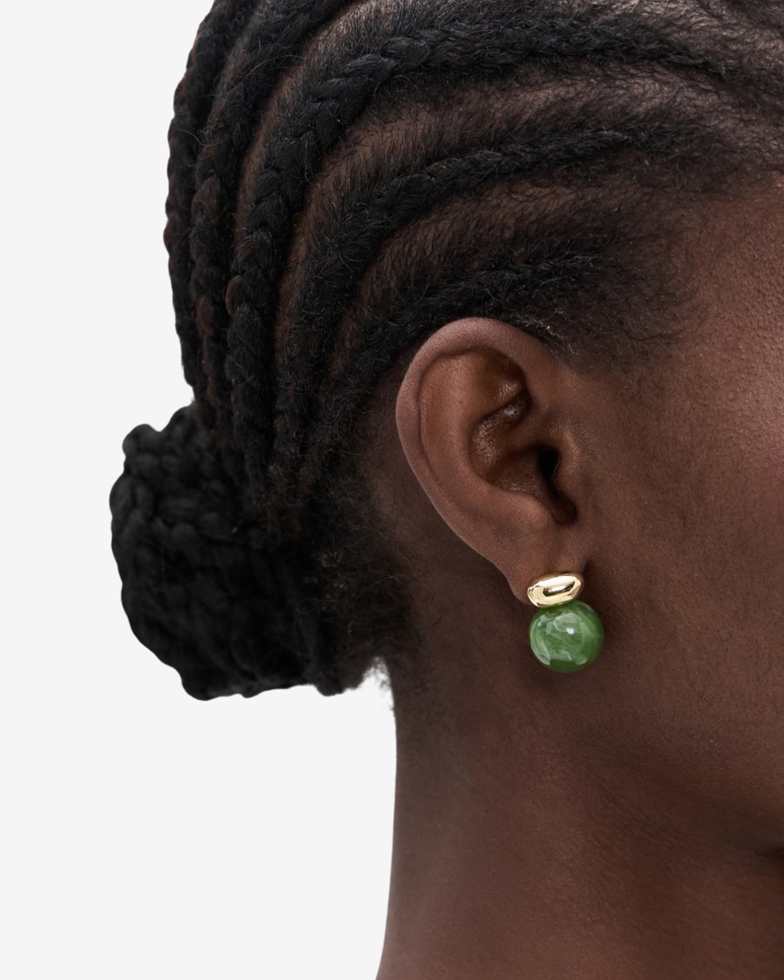 gold earring with a green gemstone hanging