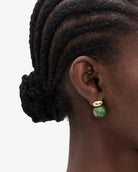 gold earring with a green gemstone hanging