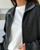 Woman wearing a dark gray  zip up knit jacket 