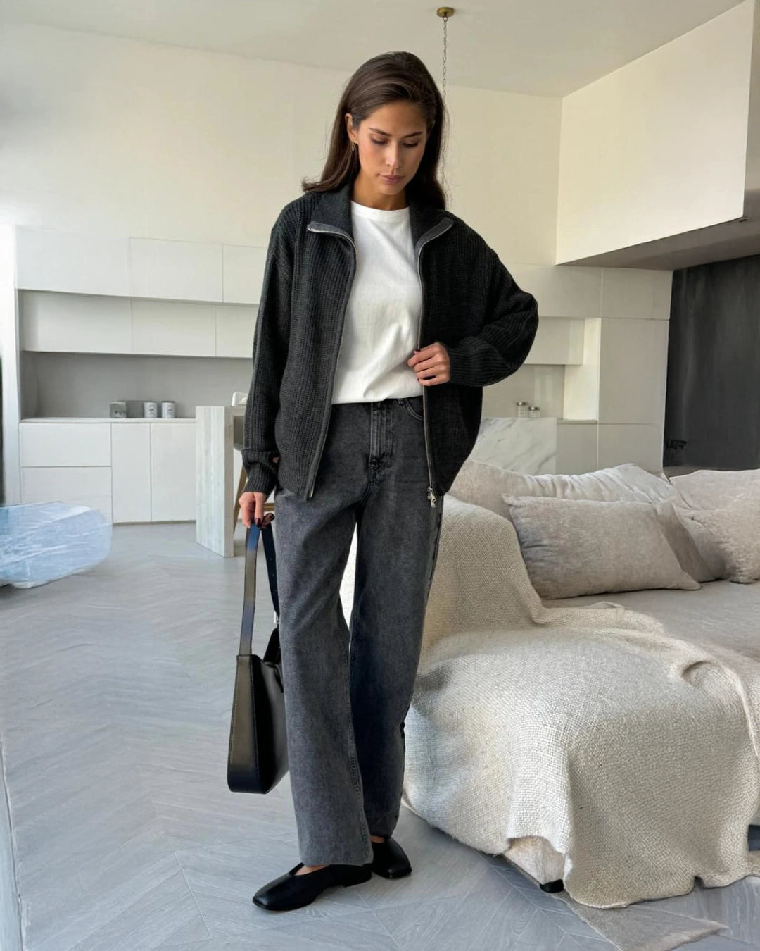 Woman wearing a dark gray  zip up knit jacket 