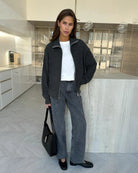 Woman wearing a dark gray  zip up knit jacket 