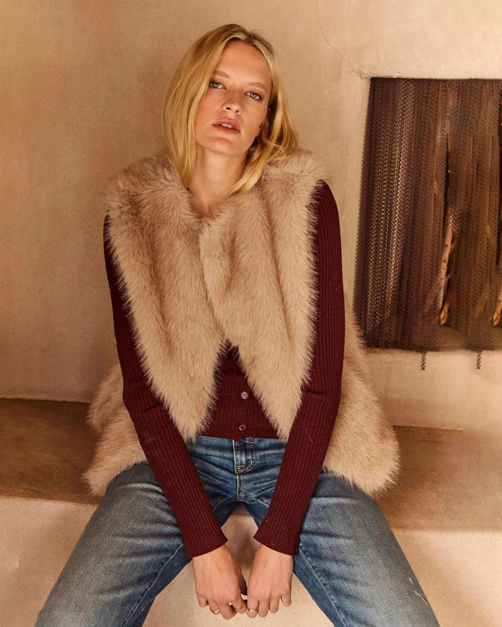 Woman wearing a beige faux fur vest