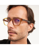 eyeglasses with a brown/olive frame and tortoise arms