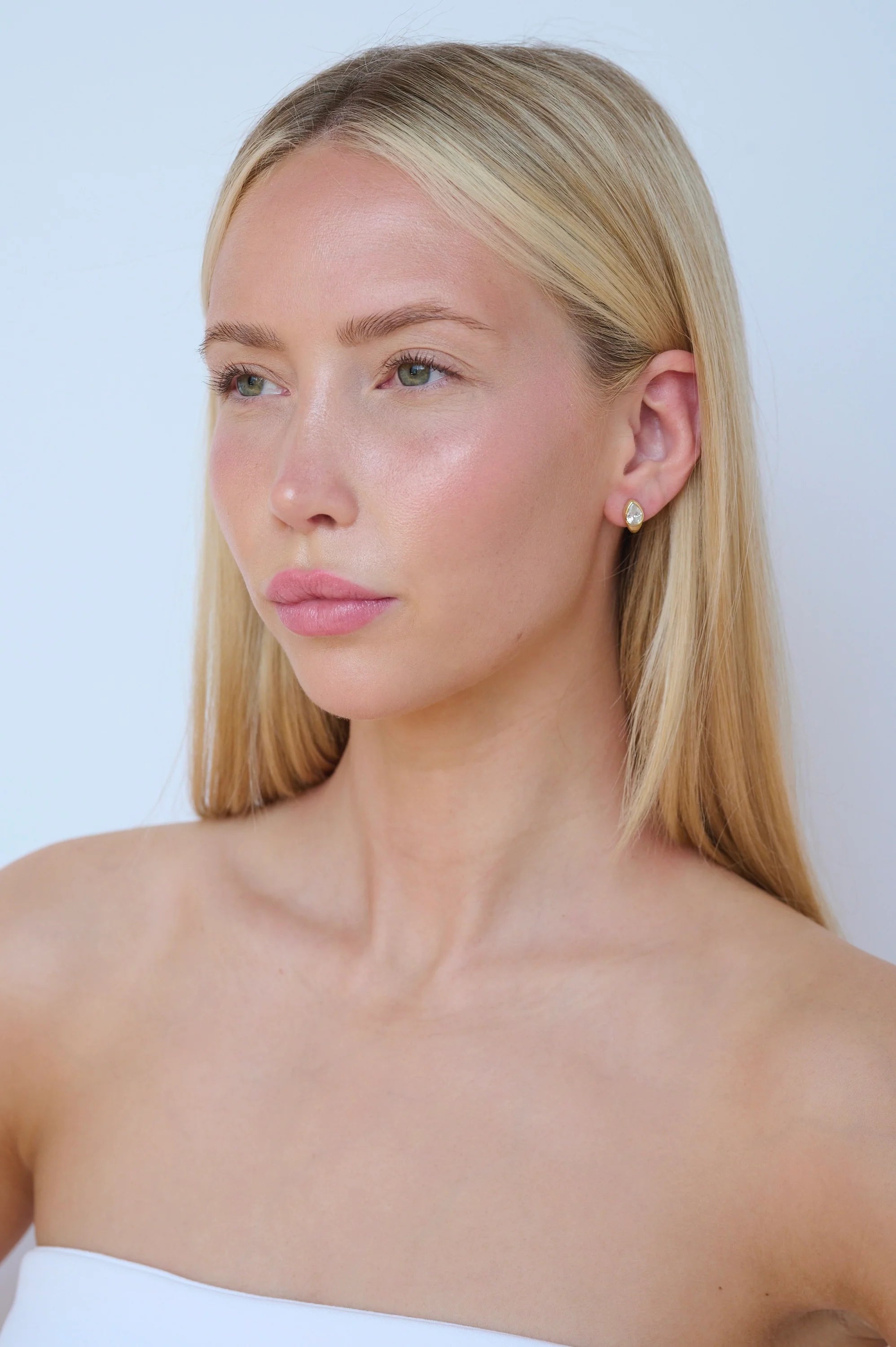 mini huggie earring in silver or gold with a diamond on the top