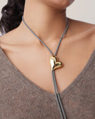 string tie necklace with a gold heart pendant