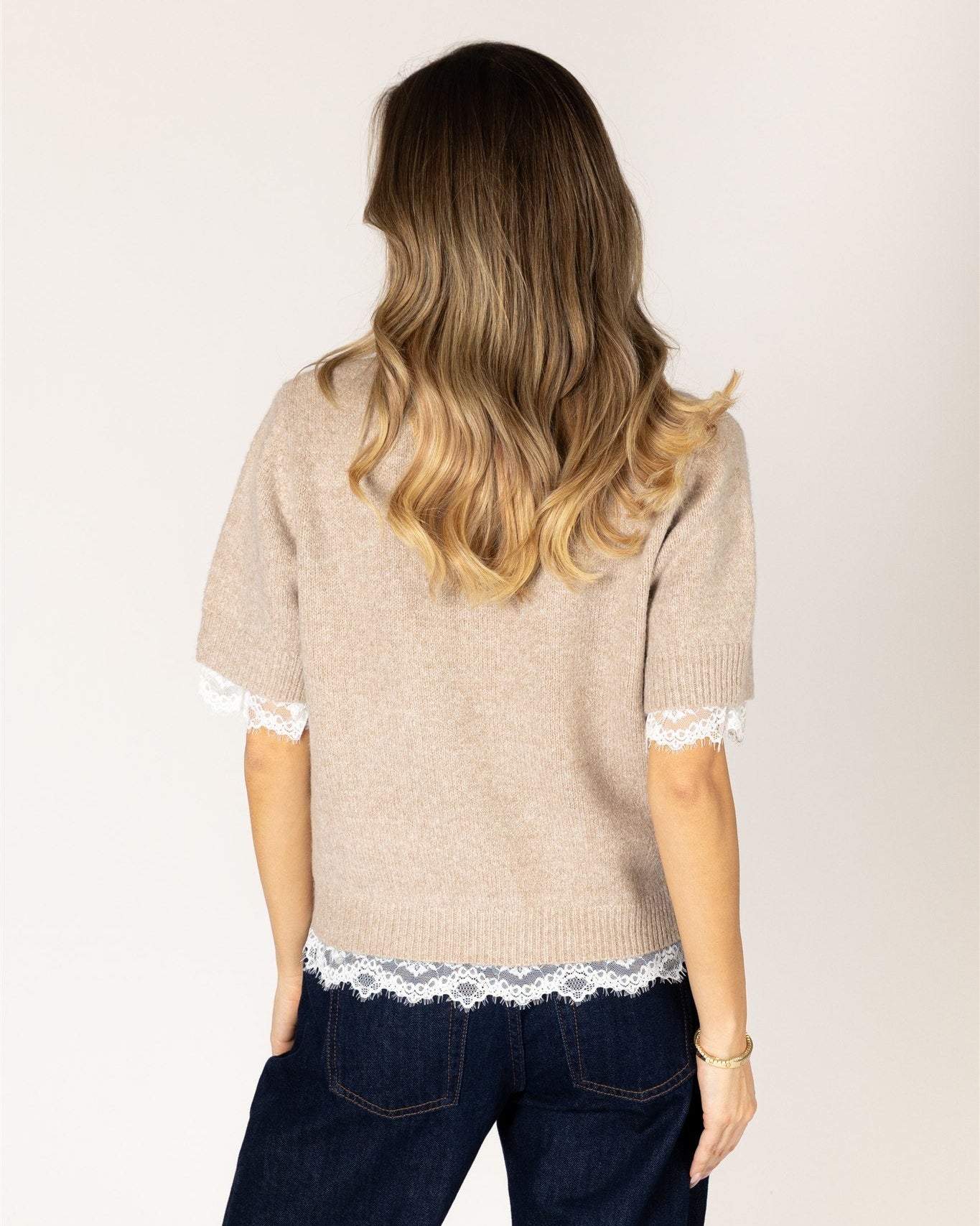 short sleeve knit top in beige with lace detail on bottom and sleeves
