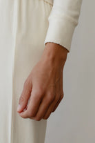 long sleeve top in cream with scalloped edges