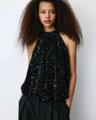black sleeveless top in black sequins and a tie at the back