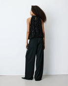 black sleeveless top in black sequins and a tie at the back