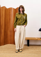 button up cardigan in khaki green with a knit flower on one side of the chest