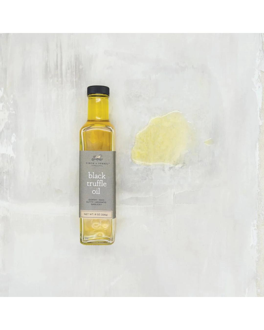 Bottle of black truffle oil on a textured white background