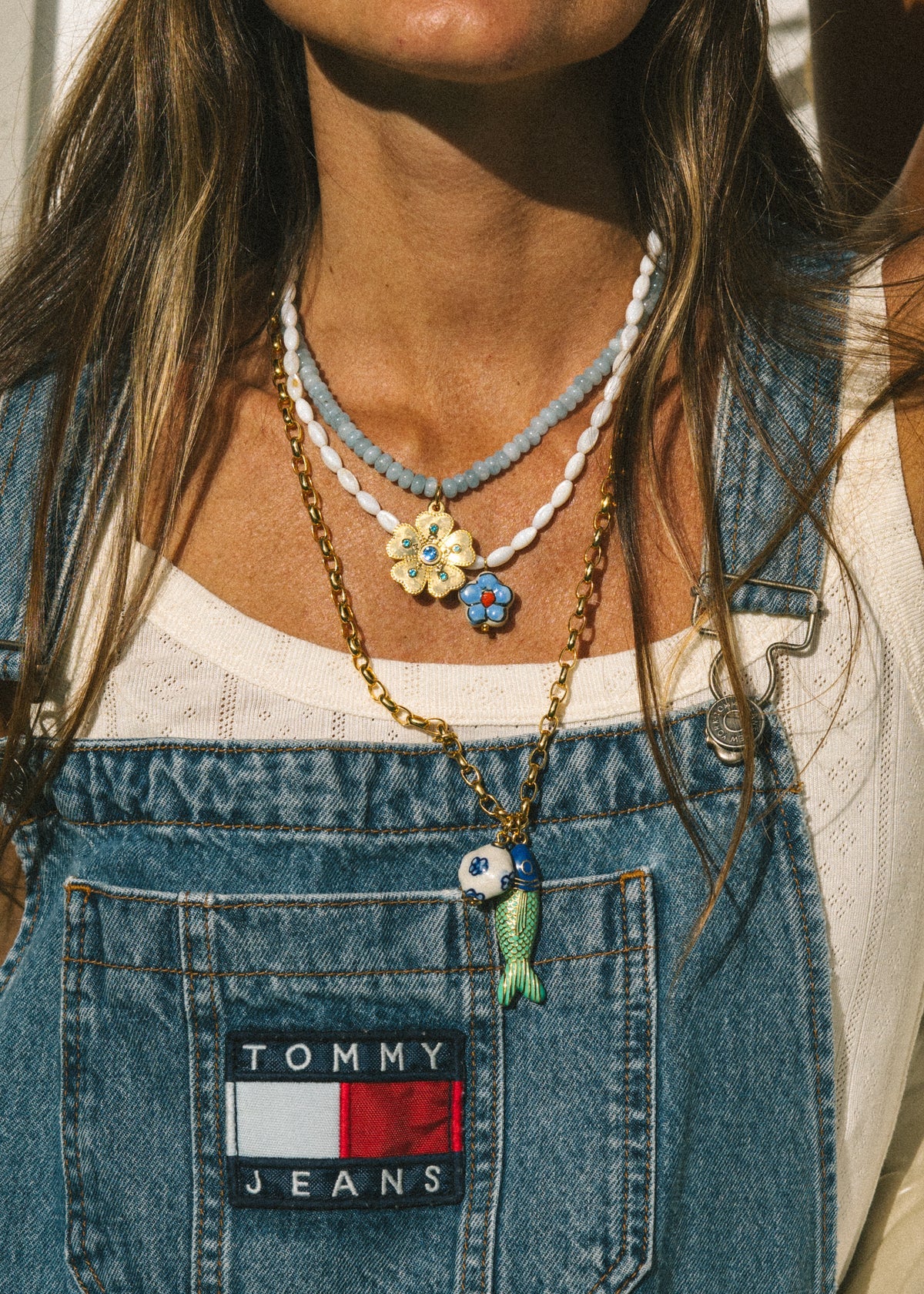 blue beaded necklace with gold flower pendant 
