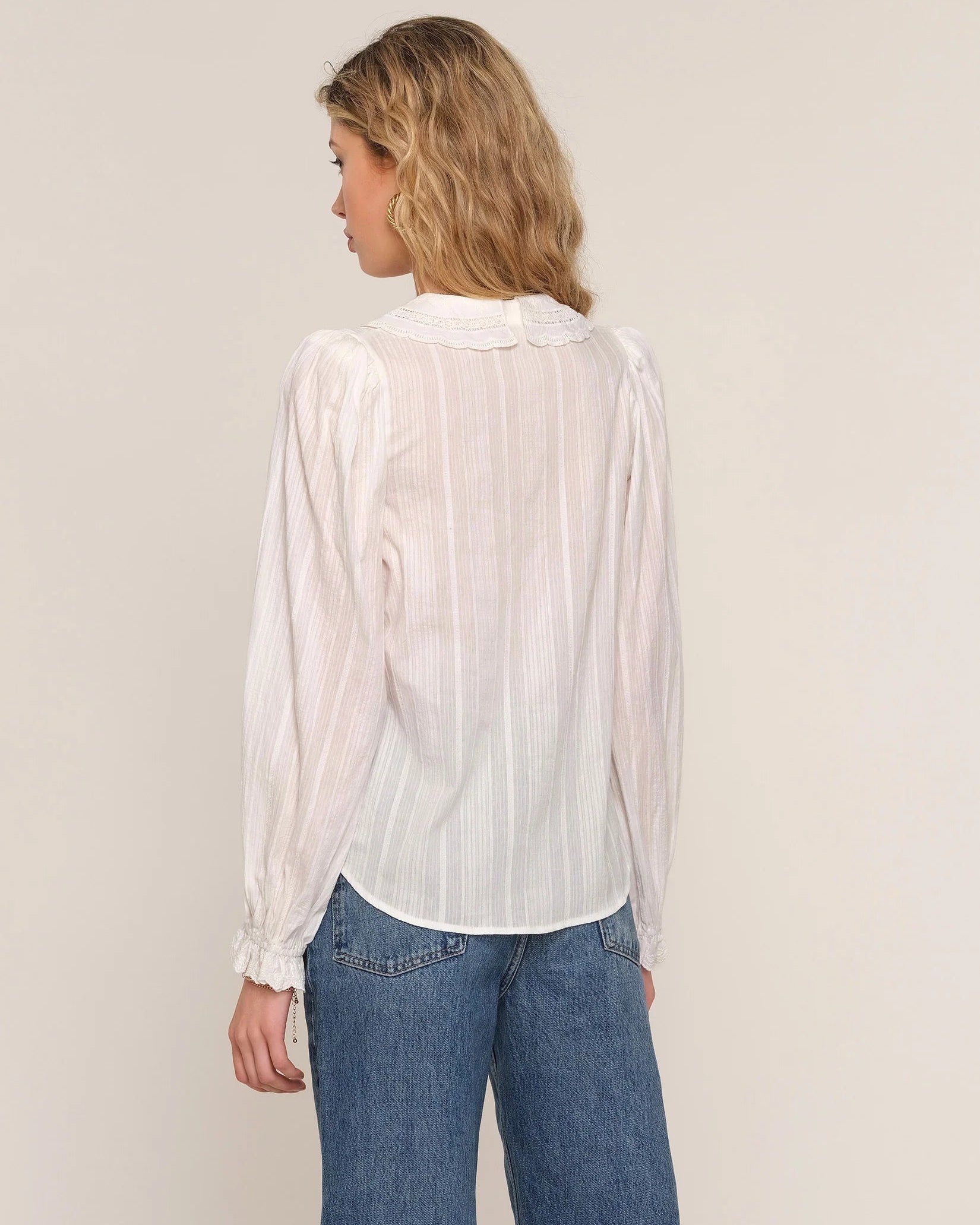 white blouse with lace trim on sleeves and collar