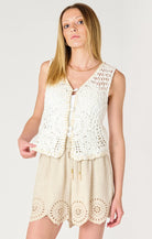 a crochet off white vest that does up in the front with buttons