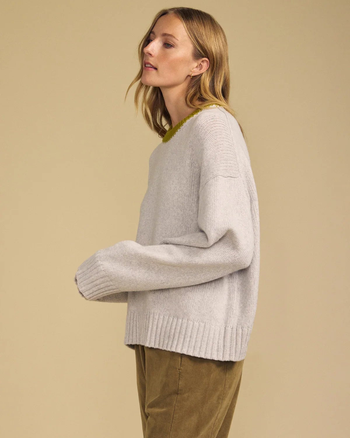 light grey sweater with green trim on neck