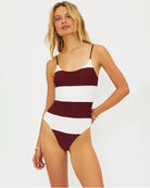 Woman wearing a burgundy and white striped swimsuit