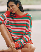 Woman wearing a red, green, and pink striped knit sweater 