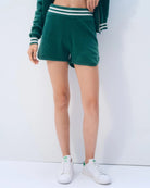 A woman wearing green cashmere varsity styleshorts and a matching top with white stripes