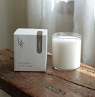 candle in glass jar beside a box