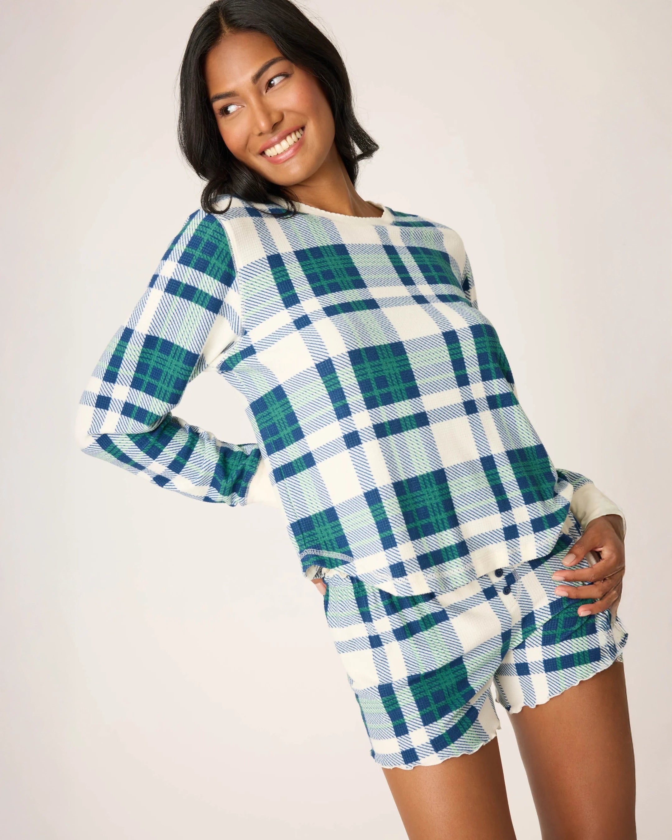 Woman wearing a blue, green and white plaid pyjama set