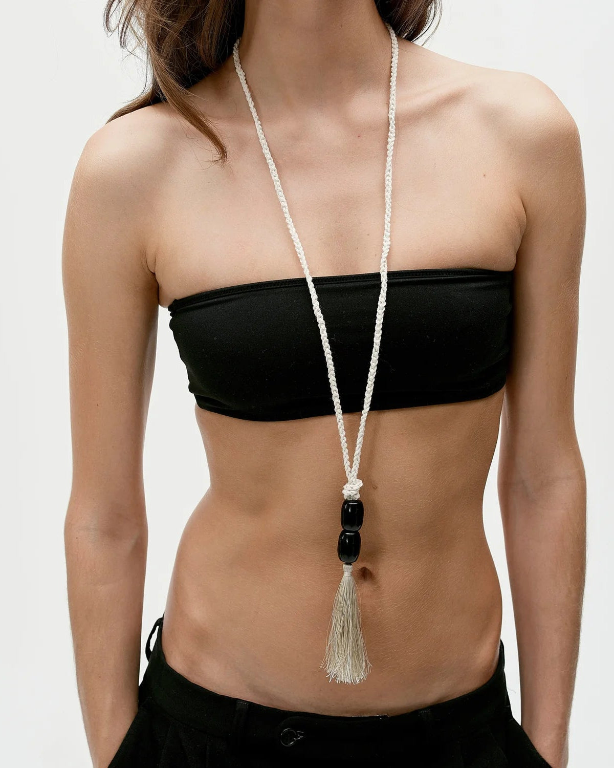 long white necklace with black beads and a tassel at the end