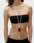 long white necklace with black beads and a tassel at the end