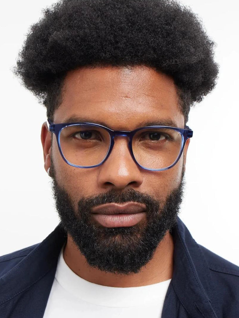 a man wears a pair of blue square eyeglasses for blue light by Barner