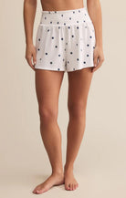 White shorts with star pattern worn by a person on a beige background