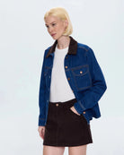 a woman wears a relaxed denim jacket with brown corduroy collar detail