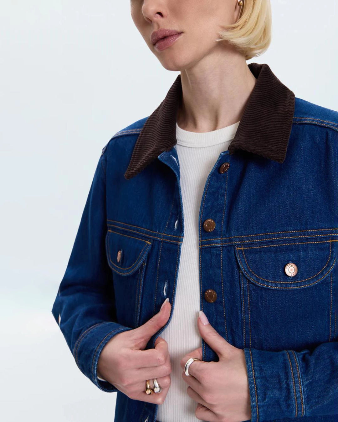 a woman wears a relaxed denim jacket with brown corduroy collar detail