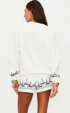 white lounge shorts with navy sailboats on the bottom 