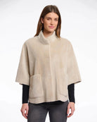 Woman wearing a beige faux fur cape in beige