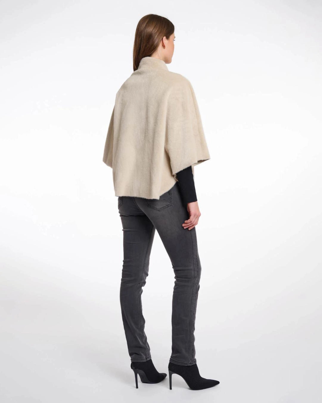 Woman wearing a beige faux fur cape in beige