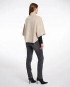 Woman wearing a beige faux fur cape in beige