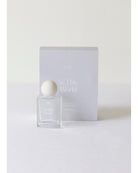 Perfume bottle and packaging with 'In This World' branding on a white background