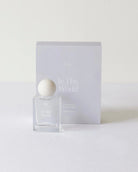 Perfume bottle and packaging with 'In This World' branding on a white background