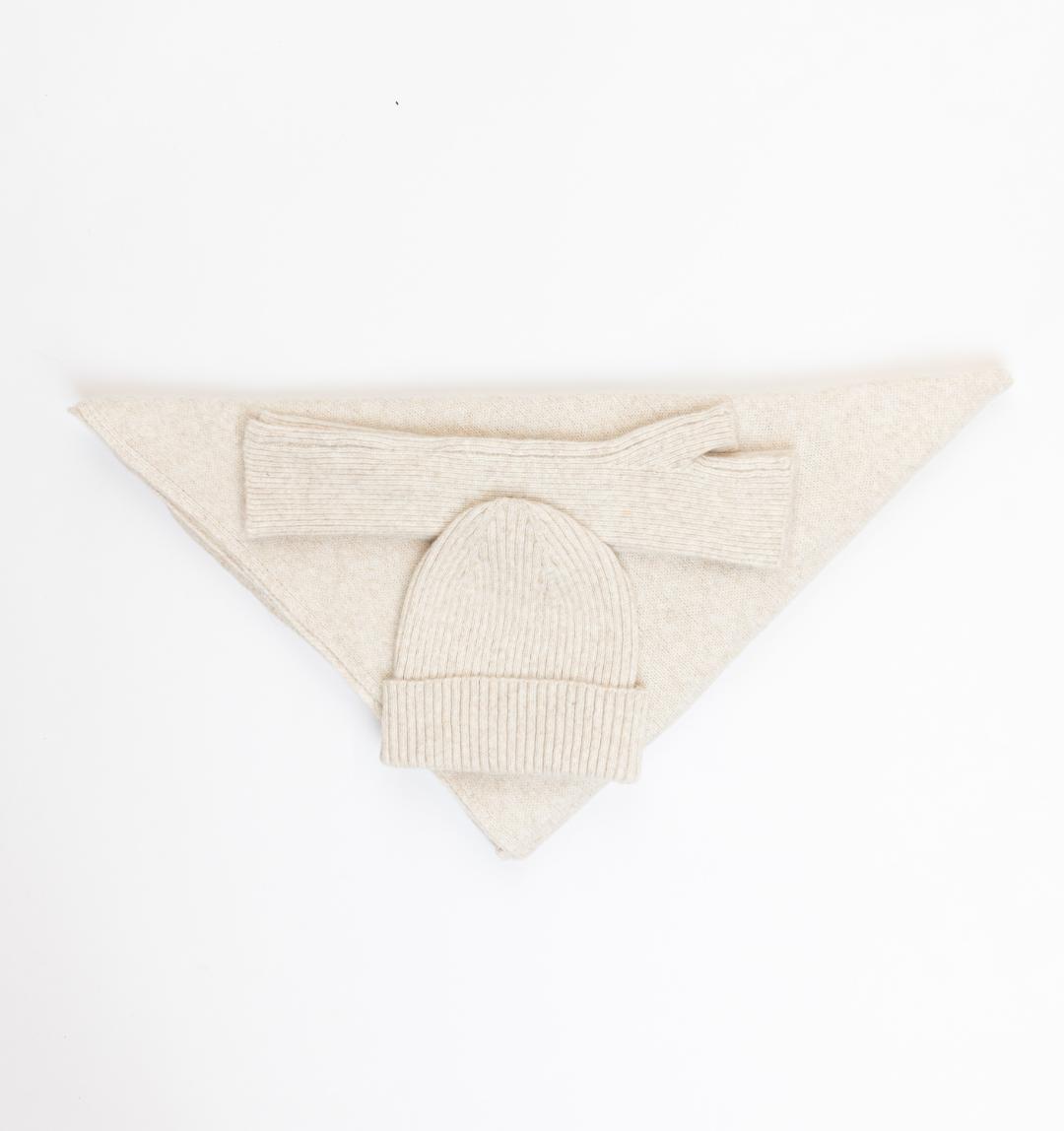 beige knit beanie laid down with matching scarf and mitts