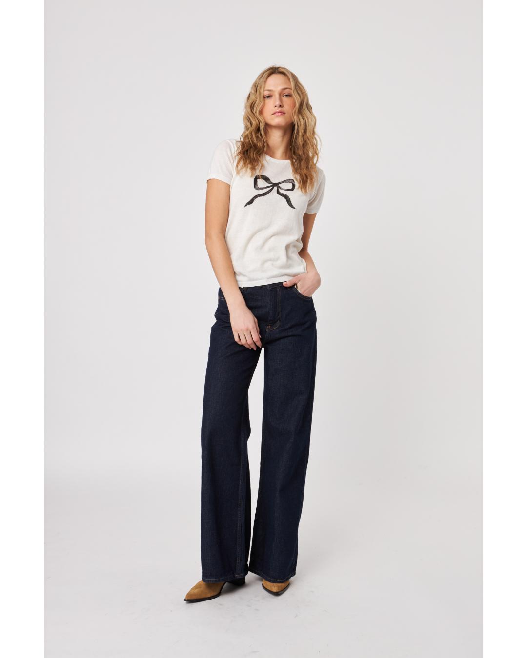 white knit top with a black bow on the front