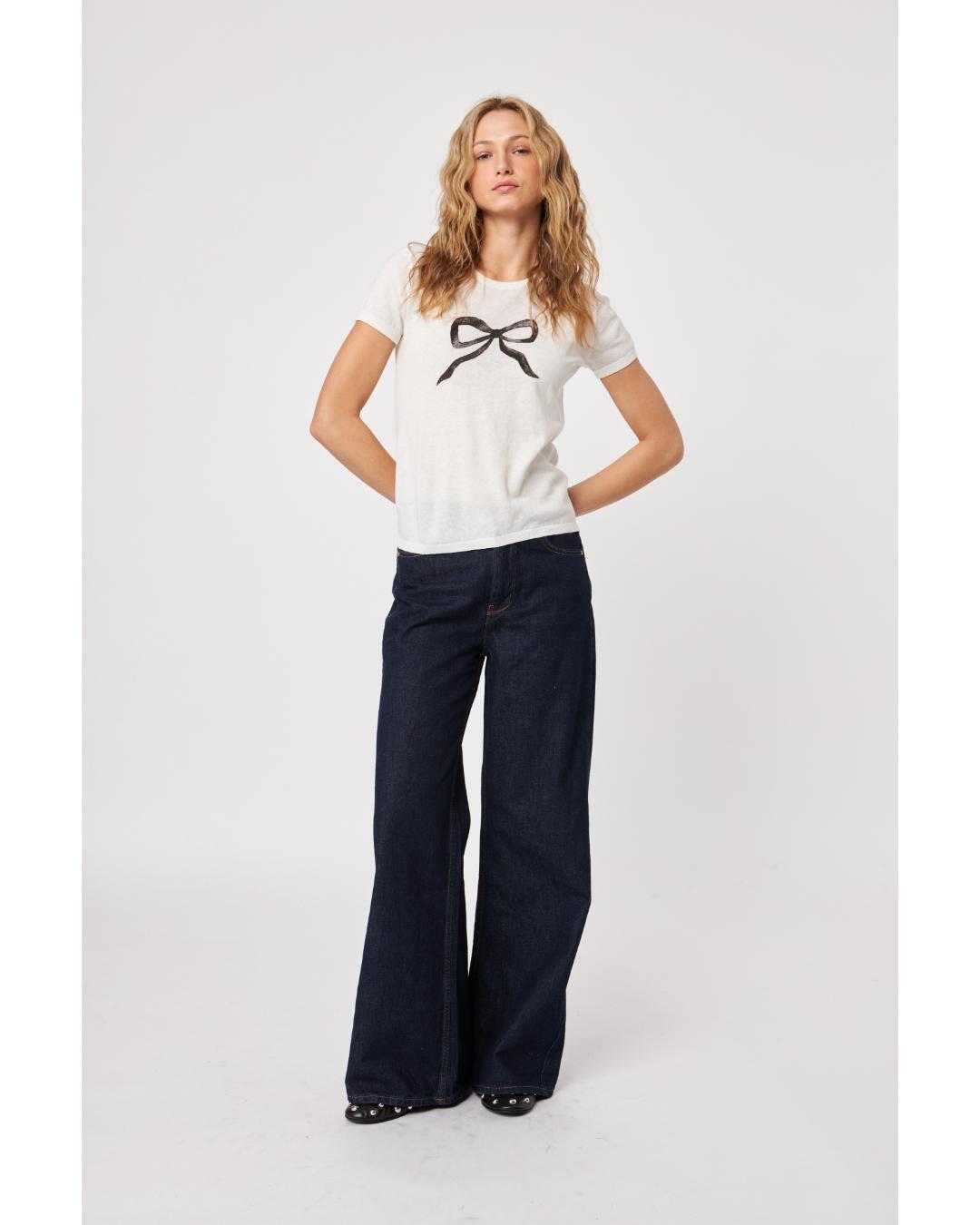 white knit top with a black bow on the front