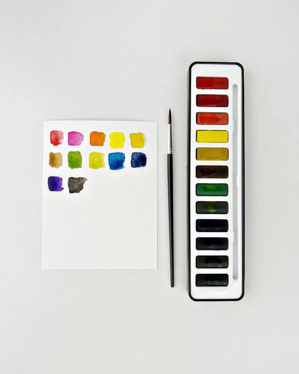 Set of watercolour paints with a brush and open case and swatches