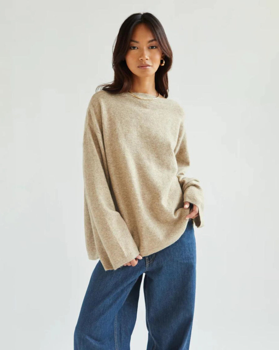 a woman wears a reversible cardigan sweater in beige 