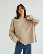 a woman wears a reversible cardigan sweater in beige 