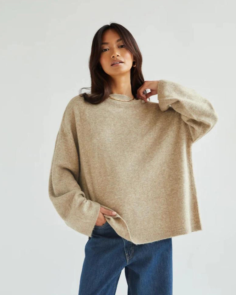 a woman wears a reversible cardigan sweater in beige 