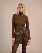 Woman wearing brown leather shorts