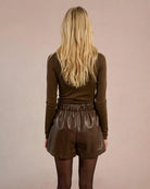 Woman wearing brown leather shorts