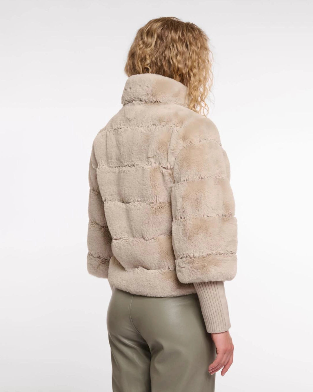 a woman wears a faux fur jacket by Rino & Pelle