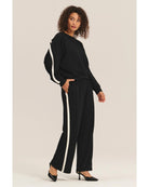 black crewneck sweatshirt with a white stripe across the back and arms