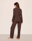 Woman wearing a chocolate brown set of modal pajamas with ivory piping by Eberjey